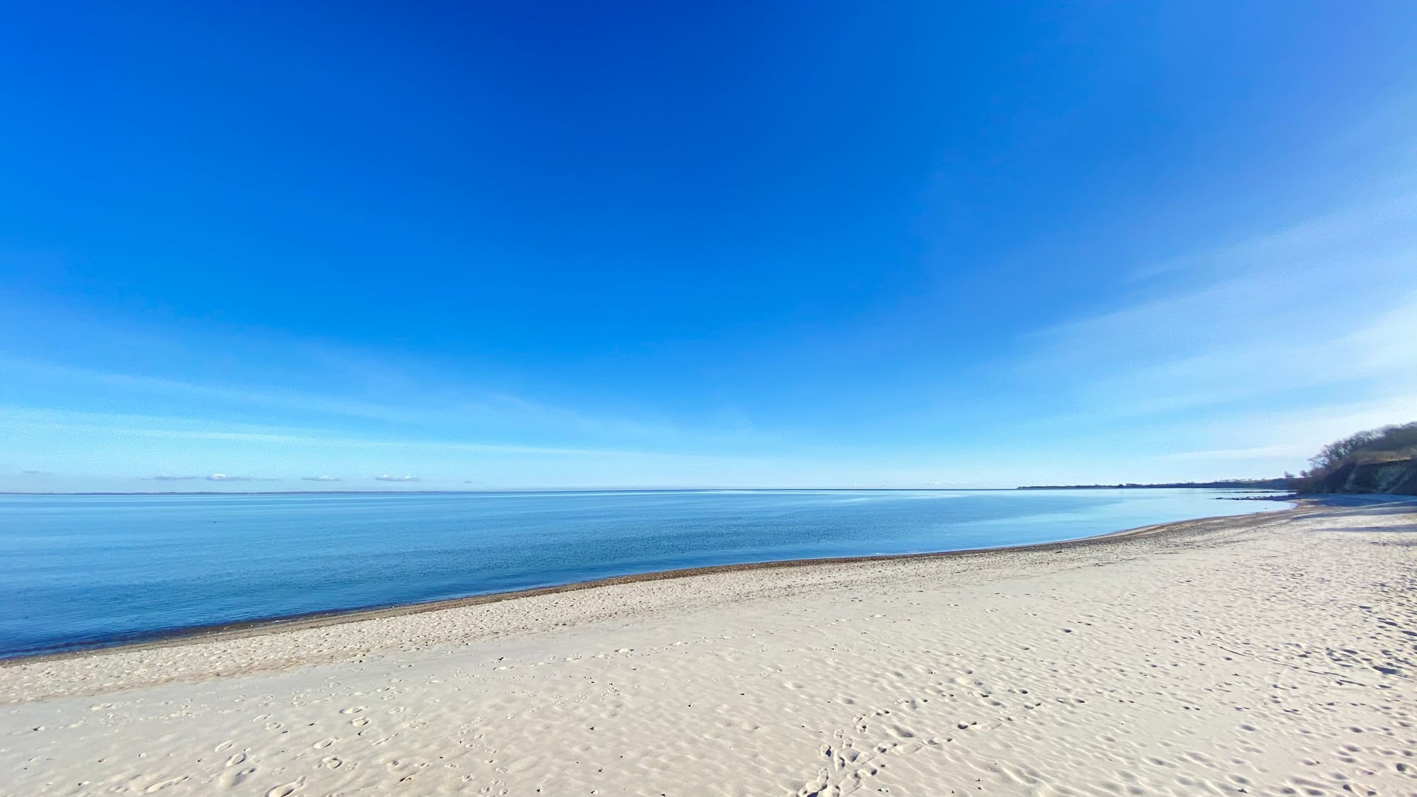 Ruhiger Sandstrand und blaues Meer bei Mommark